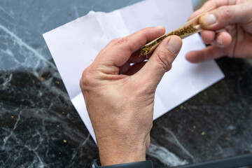 Crafting A Cannabis Joint With Care At A Smooth Surface