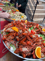 Crayfish platter at seaside resort buffet. Bright bowl of red crayfish placed on a table in an open-air restaurant area.