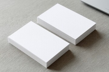 Two stacks of blank business cards on a light gray surface