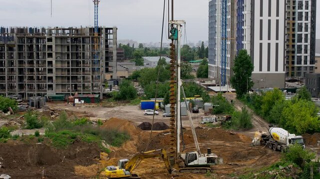 Drilling rig cleaning auger from soil cuttings at construction site