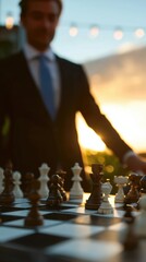 Businessman in suit carefully moving queen chess piece on large outdoor chessboard with soft-focus blurred nature background, golden hour lighting, dynamic macro close-up and focused composition symbo