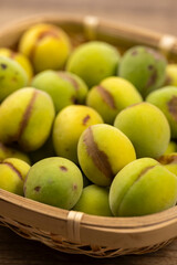 竹かごに痛みや斑点のある青梅のアップ