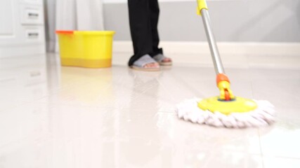Woman cleaning kitchen table indoors with gloves and cleaning products, performing housework as part of hygiene and domestic cleaning service routine