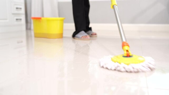 Woman cleaning kitchen table indoors with gloves and cleaning products, performing housework as part of hygiene and domestic cleaning service routine - Powered by Adobe