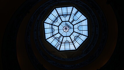 Octagonal glass dome ceiling viewed from below in a spiral architectural structure © Emilio