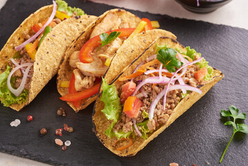 Mexican tacos with meat, pork carnitas street tacos in yellow corn tortilla with onion, cilantro and cabbage. red cabbage. Top view. flat lay.
