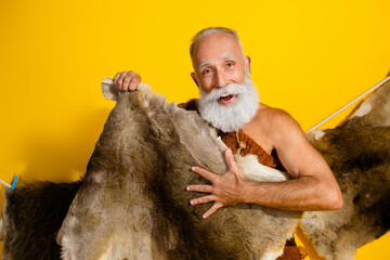 Photo of funky primeval man dressed leopard fur smiling showing animal skin copy space isolated yellow color background