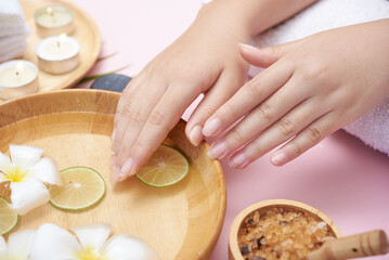 Woman soaking her hands in bowl of water and flowers, Spa treatment and product for female feet and...