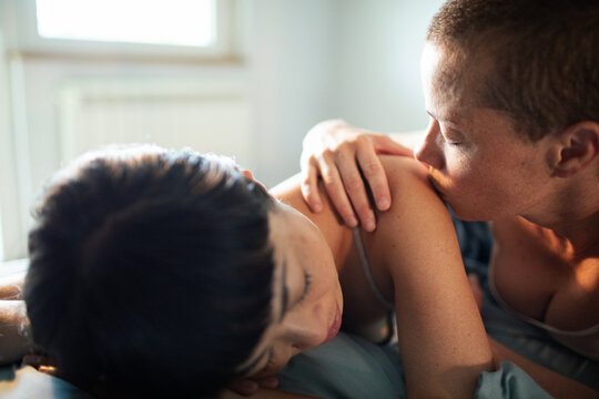 Lesbian couple sharing a tender and intimate moment in bed