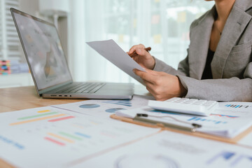 Businessman analyzing financial charts and documents at office desk, focused on planning, investment, accounting, growth strategy, and corporate success