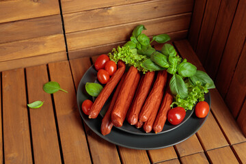 Thin smoked Polish sausages on a black plate.