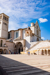 Fototapeta premium Tourists walk near the Basilica of Saint Francis in Assisi, Italy, a UNESCO World Heritage Site and a major pilgrimage destination