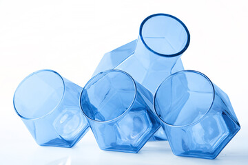 A set of four tinted transparent glass vessels, including a decanter and tumblers, arranged on...