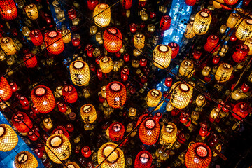 Chinese lanterns illuminated on the ceiling reflecting in the mirrors