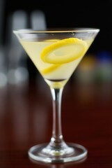 Lemon Zest Cocktail: A close-up shot of a vibrant cocktail, meticulously garnished with spiral lemon zest, exudes an atmosphere of refreshment and elegant drinking.