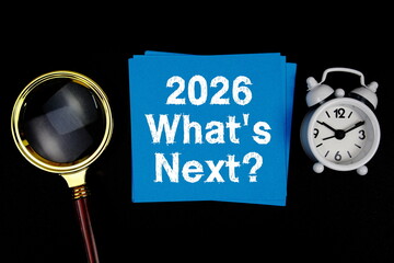 2026 What's Next? text with magnifying glass and alarm clock on black background