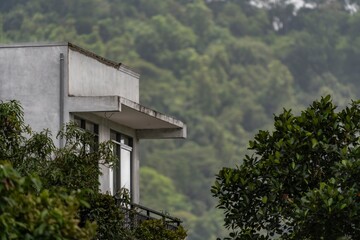 A house with a balcony and trees in the background
