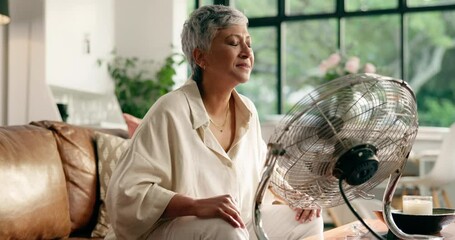 Senior woman, menopause and breathing with fan for hot flashes in relax for treatment at home. Mature, female person or smell with blowing air for relaxation technique, candle incense or calm remedy