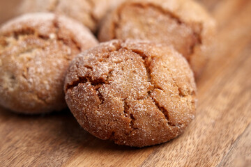 Homemade vegan gingersnap cookies on wooden table close up with crispy cracked crust texture