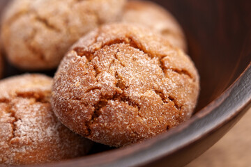 Ginger snap cookies in wooden bowl. Crumbly crispy baked snack with cracked texture. Macro. 