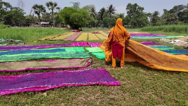 Workers drying fabrics the sun in a batik factory, Comilla, Bangladesh