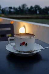  Enjoy a serene moment with a hot cup of coffee, perfect for relaxing outdoors. This beautiful floral cup adds a touch of charm to your peaceful evening.