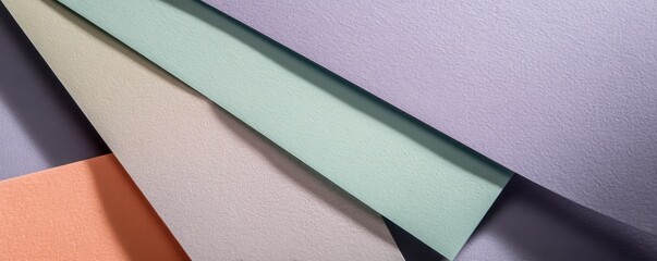 Top-down view of pastel paper sheets layered with geometric composition, soft shadows, copy space