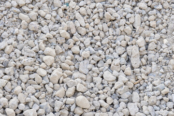 大小の石が混ざった建設用の灰色の砂利。乾いた地面の背景テクスチャー
