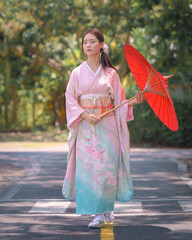 Pretty young Asian Japanese woman in Traditional Yukata Dress. A young Asian girl is wearing a...