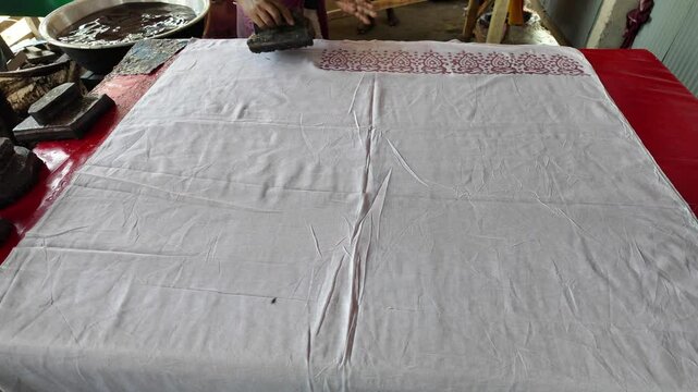 Bangladeshi man stamping wax on a cloth in a batik factory, Comilla, Bangladesh