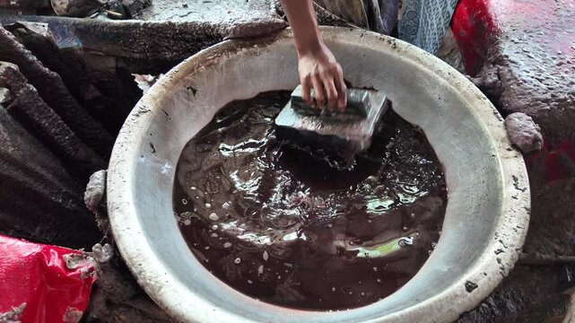 Bangladeshi man stamping wax on a cloth in a batik factory, Comilla, Bangladesh