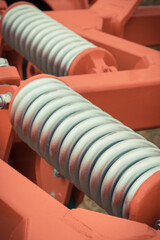 Silver hard spring made of steel. Part of big industrial or agricultural machine