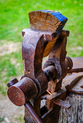 Vintage woodworking vise showcased in a rustic workshop setting with tools and cabinets arranged behind it