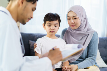 Fototapeta premium Asian muslim woman take her son the see a doctor in hospital.