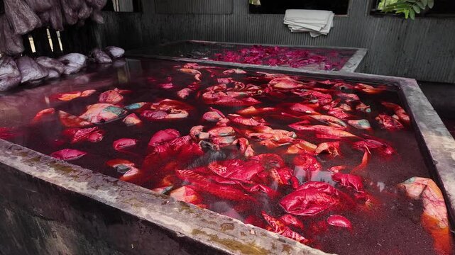 Bangladeshi man dyeing fabrics in a batik factory, Comilla, Bangladesh