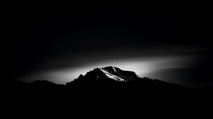 Monochrome mountain peak under dramatic sky