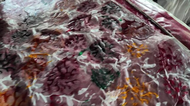Bangladeshi man stamping wax on a cloth in a batik factory, Comilla, Bangladesh