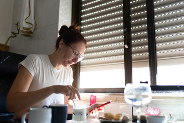 Woman enjoying breakfast and browsing smartphone at home