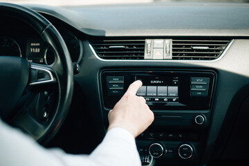 A man adjusts the sound in a car