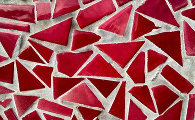 Broken tiles mosaic made with purple pink ceramic pieces background texture for design.Colorful cracked tile pattern.Interior and exterior design concept.