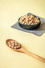 Close-up of wooden spoon filled with dry chickpeas. Minimalist composition with soft natural light...
