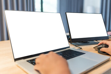 Modern home office setup with laptop and external monitor showing blank white screen. Perfect for design mockup, remote work concept, software development, and tech workspace.