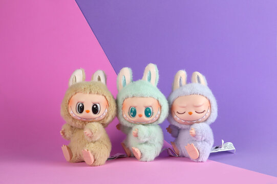 art toys Labubu key chain collection from Pop Mart blind box collectable cute toys display on pink shelf background at Pop mart flagship store during new release promotion event labubu macaron doll