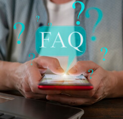 Engaging with FAQ on a smartphone while seated at a desk in a modern workspace