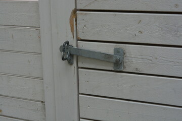 Construction, fencing, fencing of the territory from neighbors and ill-wishers. Bright beautiful white fence made of natural pine wood with a large wooden gate and a metal handle, latches.