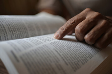 A black man is reading the scriptures or the Holy Bible. The teachings of God according to belief...