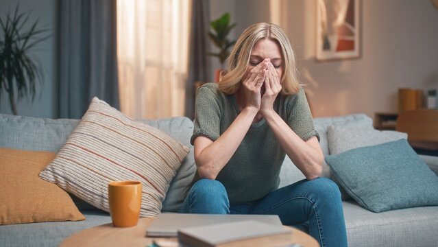 Stressed depressed pretty woman working on laptop online at home. Sad tired beautiful female closing computer finishing work. Young attractive lady sitting on sofa in living room. Work stress concept. - Powered by Adobe