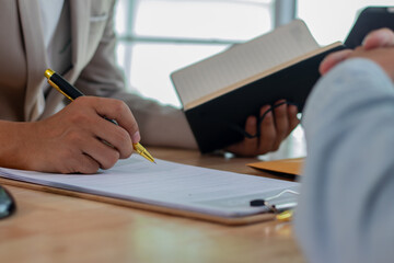 Two experts, a businessman and a lawyer, are discussing legal documents in an office, reviewing contracts, strategies and investment laws during a planning meeting.