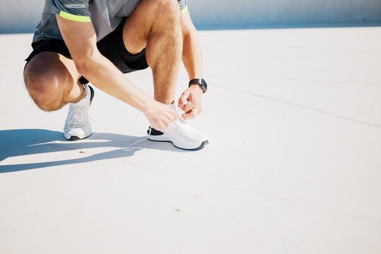 Athlete Preparing for a Run in a Sunlit Urban Environment With Fitness Gear and a Focus on Energetic Movement