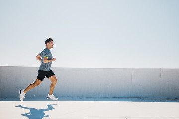 Energetic Runner Dashes Along a Sunlit Rooftop During a Bright Afternoon in a Vibrant Urban Setting